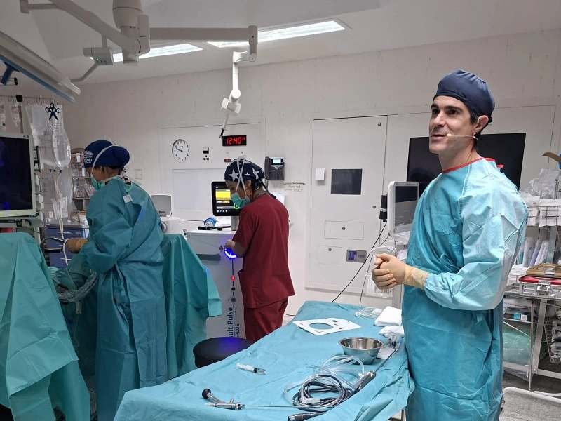 El Dr. Pérez-Carral habla con un micrófono junto al equipo de láser
