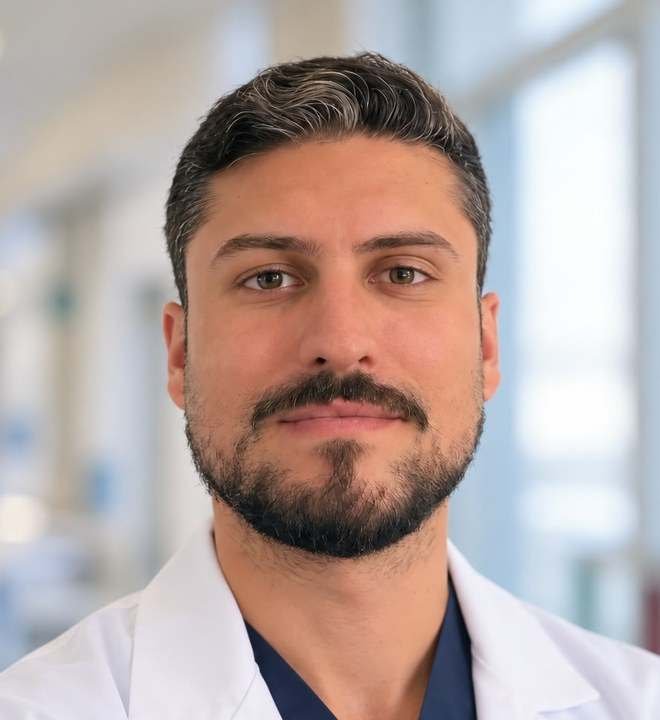 Dr. Pablo Solano Heranz, urólogo, con bata blanca y pijama quirúrgico azul marino