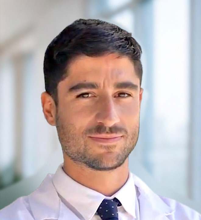 Dr. Carlos Toribio Vázquez, urólogo, con bata blanca y corbata
