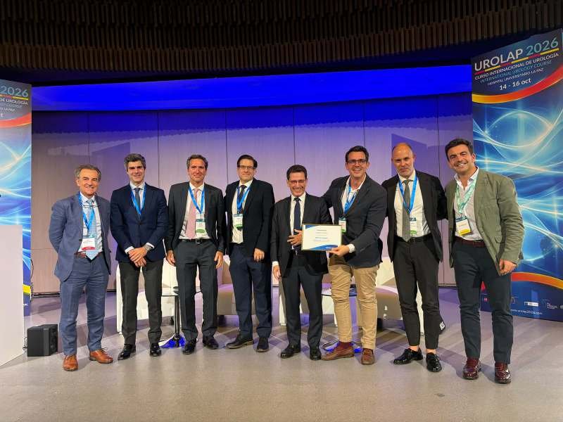 Foto de grupo de ponentes junto al roll-up de UROLAP 2026