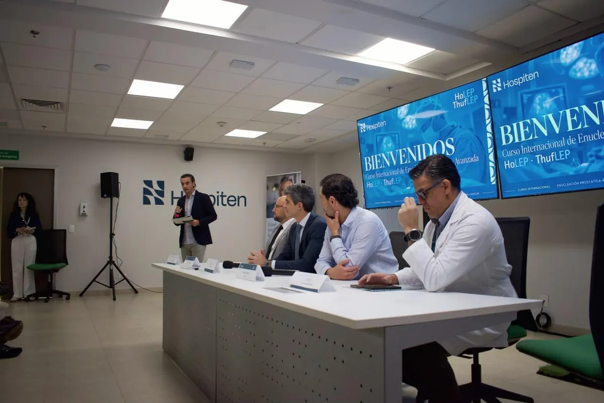 Aula del Curso Internacional de Enucleación Prostática Avanzada con la mesa de profesores y las pantallas del curso